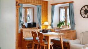 A cozy room with a wooden dining table, chairs, a lamp, a plant, and a wall-mounted wheel. - Holiday Apartment "Gästehaus Marianne" with Mountain View, Shared Terrace and Wi-Fi (Farchant)