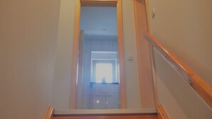 A wooden staircase with a handrail, leading to a room with a window and a door. - Holiday Home 'Viktoria' with Private Terrace, Garden, and Wi-Fi (Koblenz)
