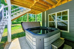 A hot tub under a wooden deck with a staircase leading to a covered area. - Lakefront Lake Anna with Cove, Dock, Deck, Hot Tub (Mineral)