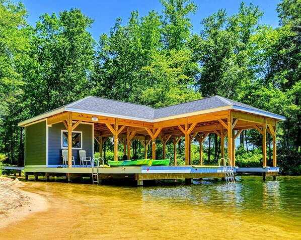 A wooden dock with a covered pavilion, a green kayak, and a chair. - Lakefront Lake Anna with Cove, Dock, Deck, Hot Tub (Mineral)
