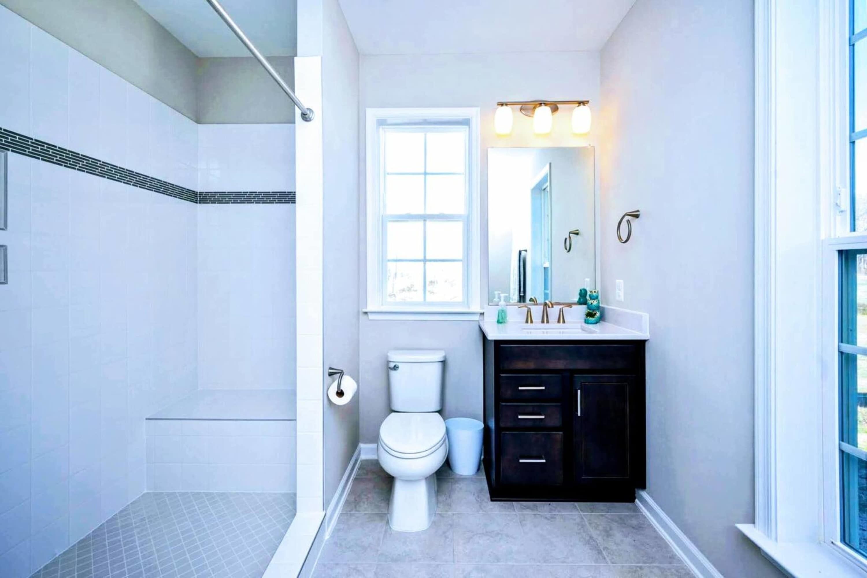 A bathroom with a toilet, sink, and shower.