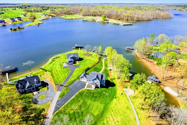 Zona residencial con casas cerca de un lago, con céspedes cuidados y cielo despejado.