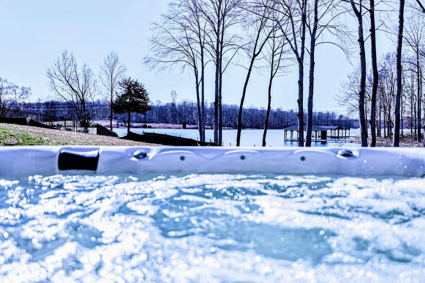 Un bain à remous avec vue sur un lac et des arbres en arrière-plan.