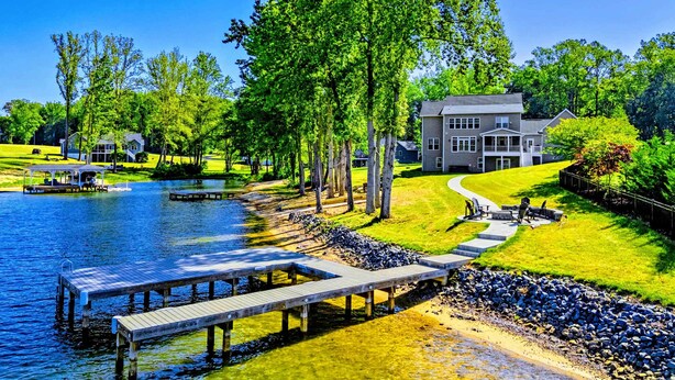 A lakeside property with a dock, a walking path, and a large house with a lawn. - Private Cove Lakefront Lake Anna Beach & Dock (Mineral)