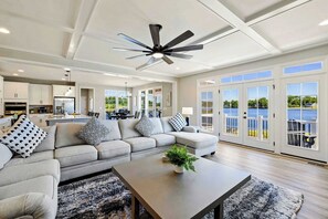 A spacious living room with a large sofa, a coffee table, and a ceiling fan. - Private Pointe Lakefront Lake Anna Beach, Dock (Mineral)