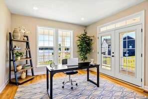 A home office with a desk, computer, and bookshelf.