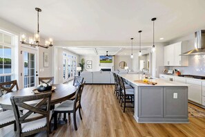 A modern kitchen with a central island, wooden dining table, and chairs. - Private Pointe Lakefront Lake Anna Beach, Dock (Mineral)