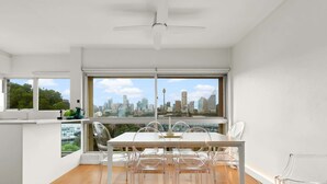 Una cocina moderna con comedor, ventanas amplias y vistas a la ciudad.