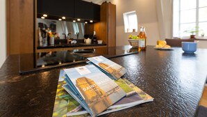 Une cuisine avec un plan de travail foncé, une cuisinière et une fenêtre.