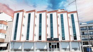 Un hotel amb façana moderna, grans finestres i una entrada destacada.