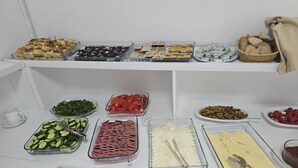 Buffet amb diferents plats, incloent-hi cogombre a làmines, tomàquets cherries i diversos tipus de formatge.