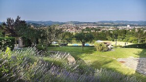 A garden with lavender, a stone pathway, and a view of a town in the distance. - Casa Gioele A: A welcoming apartment situated in a quiet location, a few minutes from the town center, with Free WI-FI. (Umbertide)