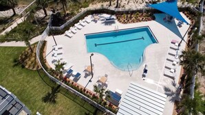 Un área de piscina con sillones de descanso y una cabaña.