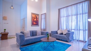 Een moderne woonkamer met twee banken, een bijzettafeltje en een schilderij van de Mona Lisa.