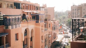 Een meerhoog gebouw met balkons, schotels en een straatbeeld.