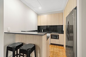 Habitación cuádruple ejecutiva, 2 habitaciones, no fumadores, cocina básica | Cocina privada | Frigorífico, microondas, placa de cocina y hervidor eléctrico