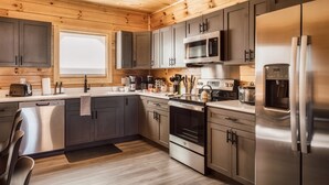 Eine moderne Küche mit Holzbalkendecke, Edelstahlgeräten und grauen Schränken.