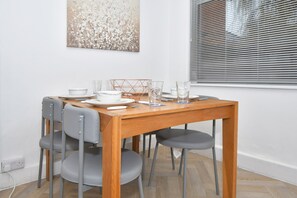 Enjoy meals in this dining area with a table for four, featuring a bowl, glass, and wicker basket.