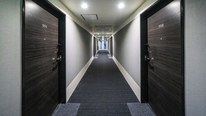 Pasillo con dos puertas identificadas con los números 551 y 558, que dan a habitaciones.