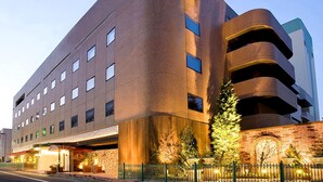 Un edificio moderno con fachada curva, numerosas ventanas y revestimiento de ladrillo.