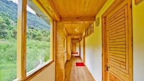Un pasillo de madera con ventanas amplias y vistas a un paisaje verde.