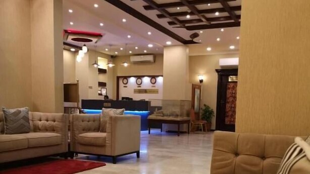 A modern lobby with a reception desk, sofas, and a ceiling with recessed lighting. - Bahla Hotel Apartment  (Bahla)