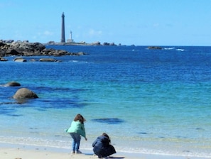 A beach with clear blue water, a lighthouse, and rocky outcrops. - Renovated Breton house 2 minutes from a pretty beach and direct access to the GR34 trails (Plouguerneau)