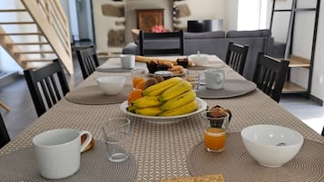 Een ontbijt staat klaar op tafel, met bananen, toast en een kom soep.