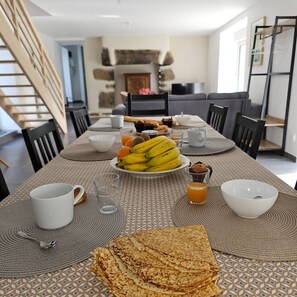 A dining table set with breakfast items including bananas, toast, and a bowl of soup. - Renovated Breton house 2 minutes from a pretty beach and direct access to the GR34 trails (Plouguerneau)