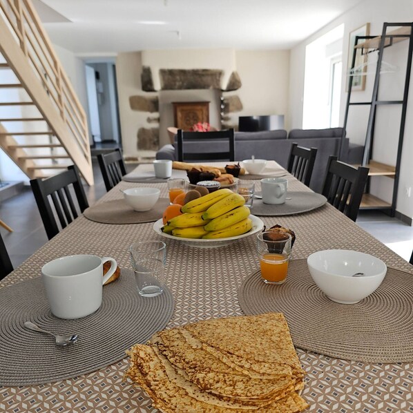 A dining table set with breakfast items including bananas, toast, and a bowl of soup.