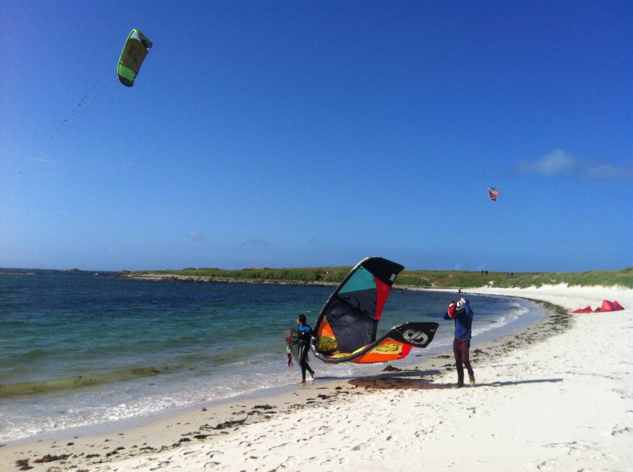 Een strand met heldere lucht en rustig water.