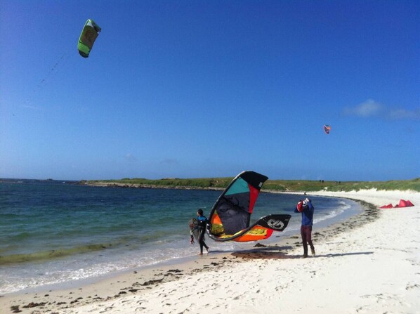 Una playa con cielos despejados y aguas tranquilas.