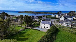 Un village côtier aux maisons traditionnelles, doté d’un phare et offrant une vue dégagée sur la mer.