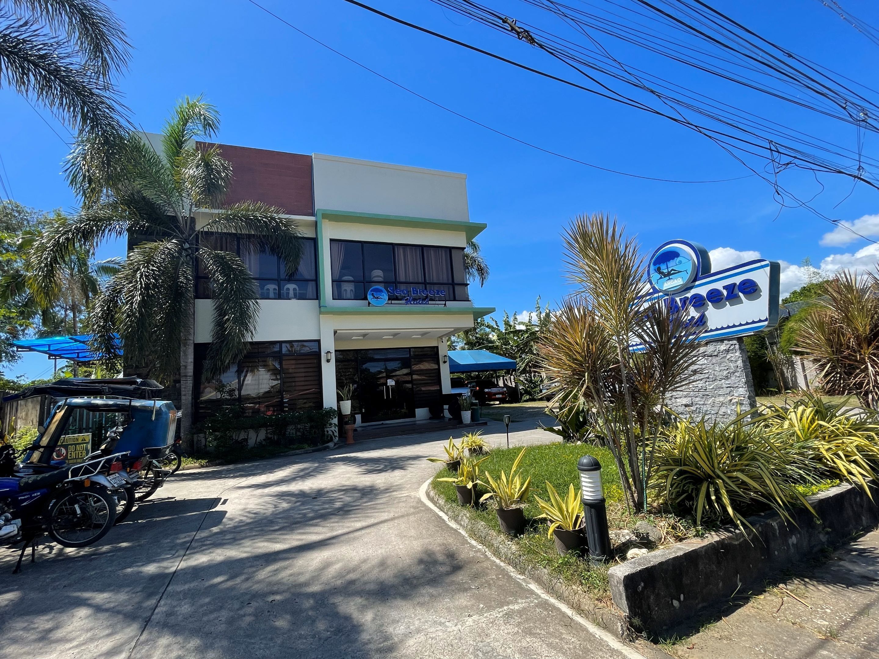 Un bâtiment à deux étages avec une enseigne indiquant « Sea Breeze Resort ».
