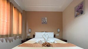 A hotel room with a neatly made bed, a painting on the wall, and a telephone on the nightstand. - Argao Seabreeze Hotel powered by Cocotel (Argao)
