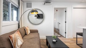 Een moderne woonkamer met een bank, een bijzettafeltje en een unieke ronde wanddecoratie.
