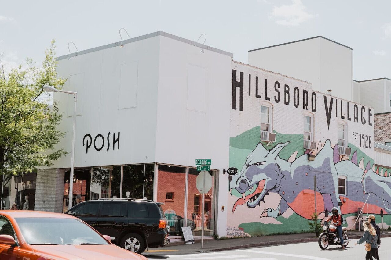 A building with a mural of a dinosaur and the text "HILLSBORO VILLAGE EST. 1920".