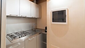 A compact kitchen with a gas stove, stainless steel cabinets, and a window. - Corte Spagnola - piano primo (Verona)