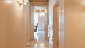 A hallway with a chandelier, a dining area with a table and chairs, and a door on the right. - Corte Spagnola - piano primo (Verona)