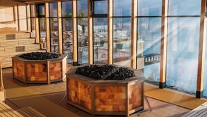 A spacious indoor area with large windows, wooden flooring, and two central stone planters. - Spacious, cozy attic apartment with mountain views on 1.5 floors (Berg)