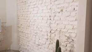 Um quarto com parede de tijolos brancos e piso de azulejos estampados.