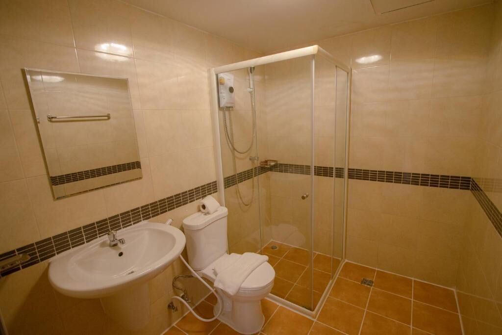 A bathroom with a sink, toilet, and glass-enclosed shower.