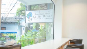 Ein Zimmer mit Blick auf eine Straße und einem Schild für RoomQuest Phuket Kalim Beach Premium Collection.