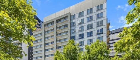 A modern multi-story building with a flat facade, large windows, and a central entrance.