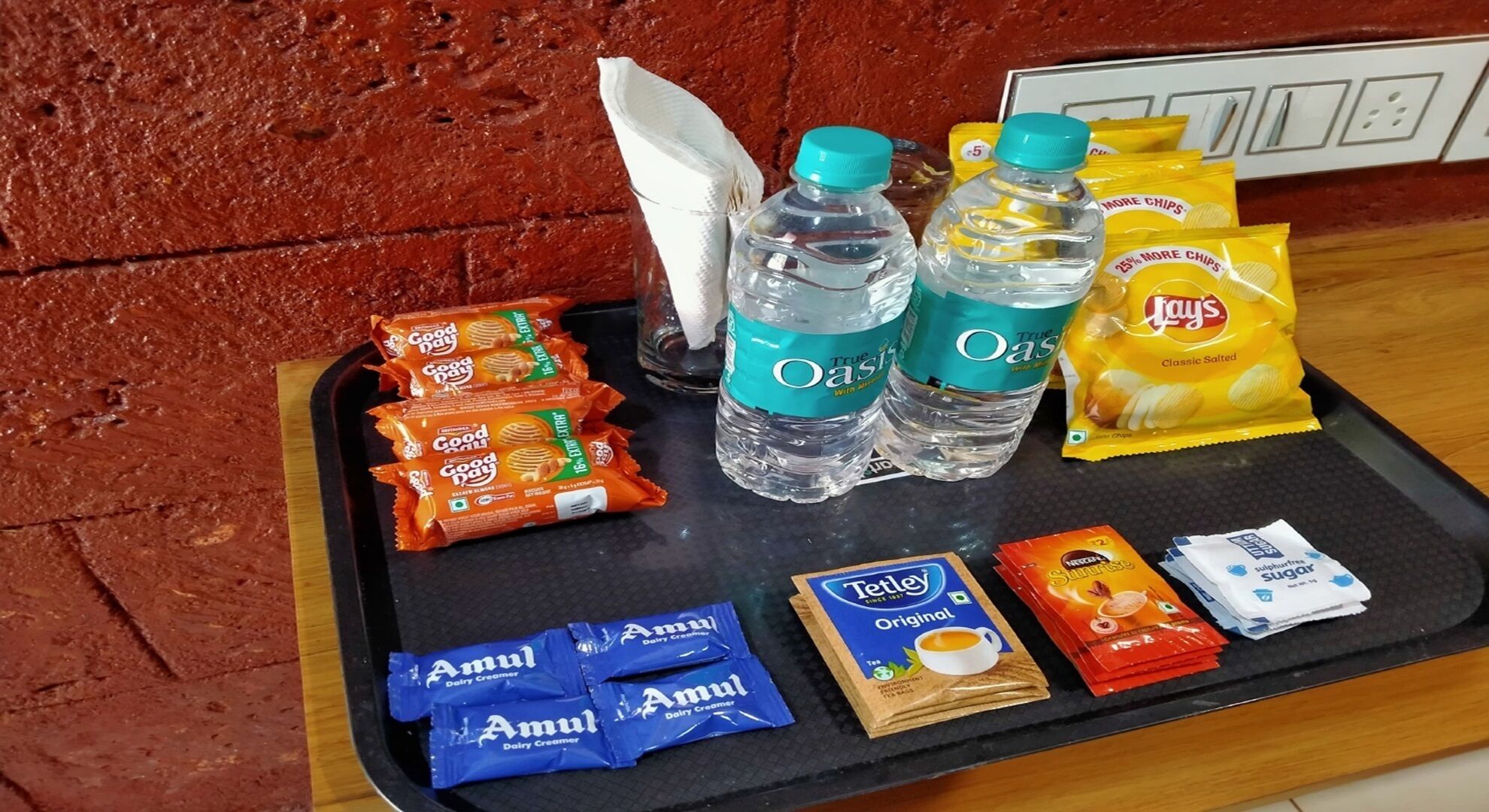 A tray with snacks, water bottles, and dairy creamer packets.
