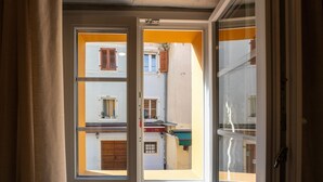 A view through a window with a white frame and a yellow wall. - Modern apartment for 2 persons in the Porec old town , only 150m from the beach. (Porec)