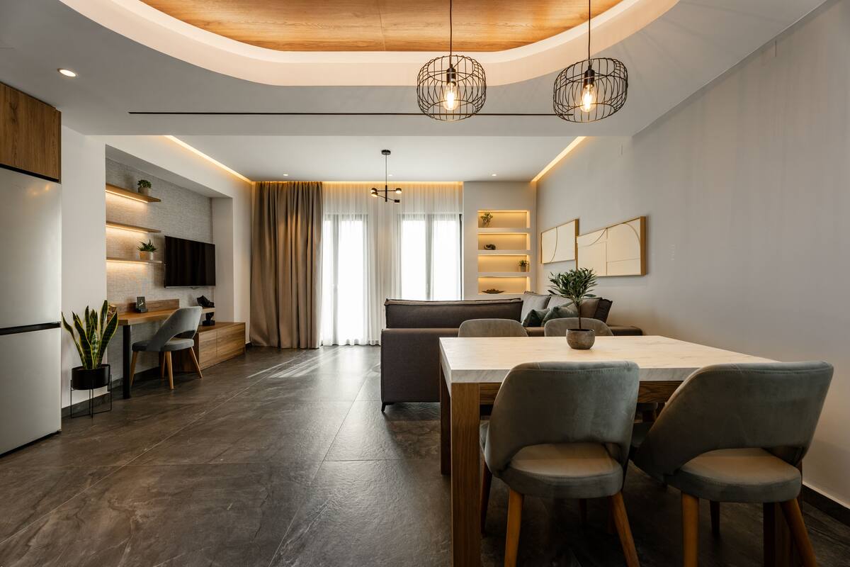 Een moderne keuken met een eethoek, houten plafond en hanglampen.