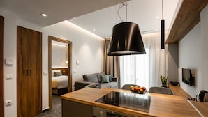 A modern kitchen with a wooden countertop, built-in oven, and a black pendant light.