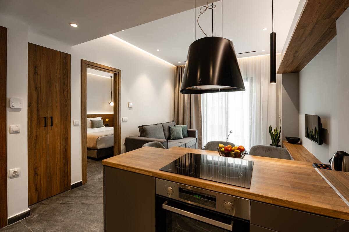 Een moderne keuken met een houten aanrecht, een ingebouwde oven en een zwarte hanglamp.