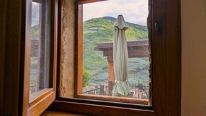 A room with a wooden bench and a window overlooking a green landscape with hills. - Perla House (Ferentillo)